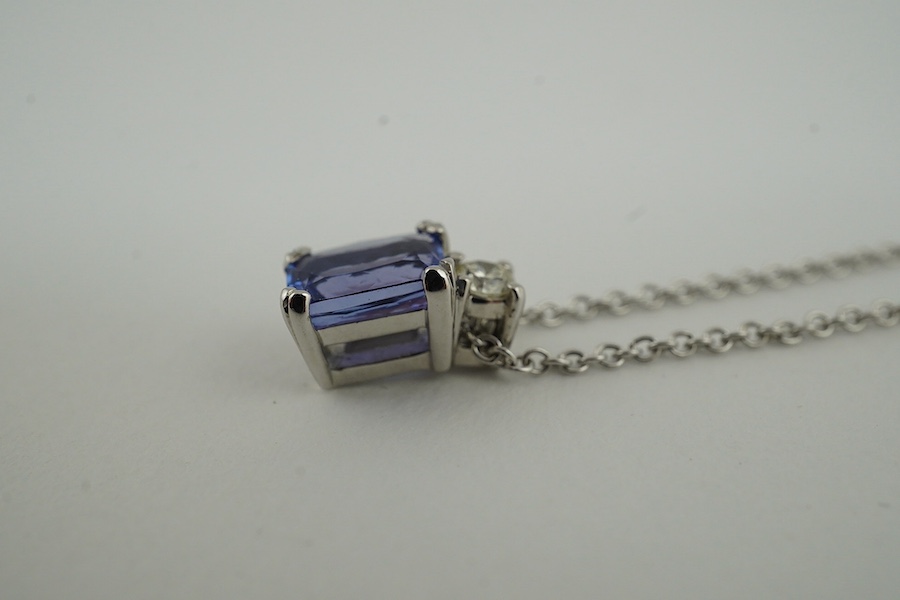 A modern 18ct white gold, tanzanite and diamond set pendant, 10mm, on an 18ct white gold chain, 39cm, gross weight 3.1 grams. Condition - good